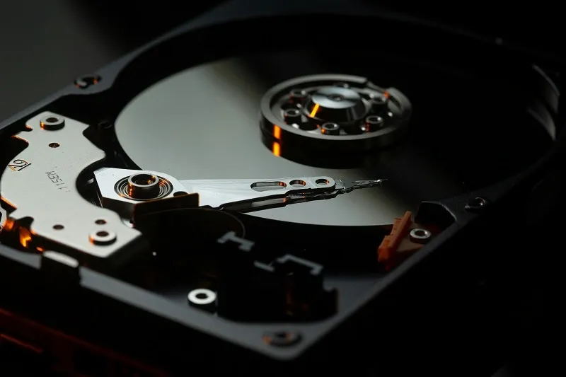Open hard drive showing the platter and read arm